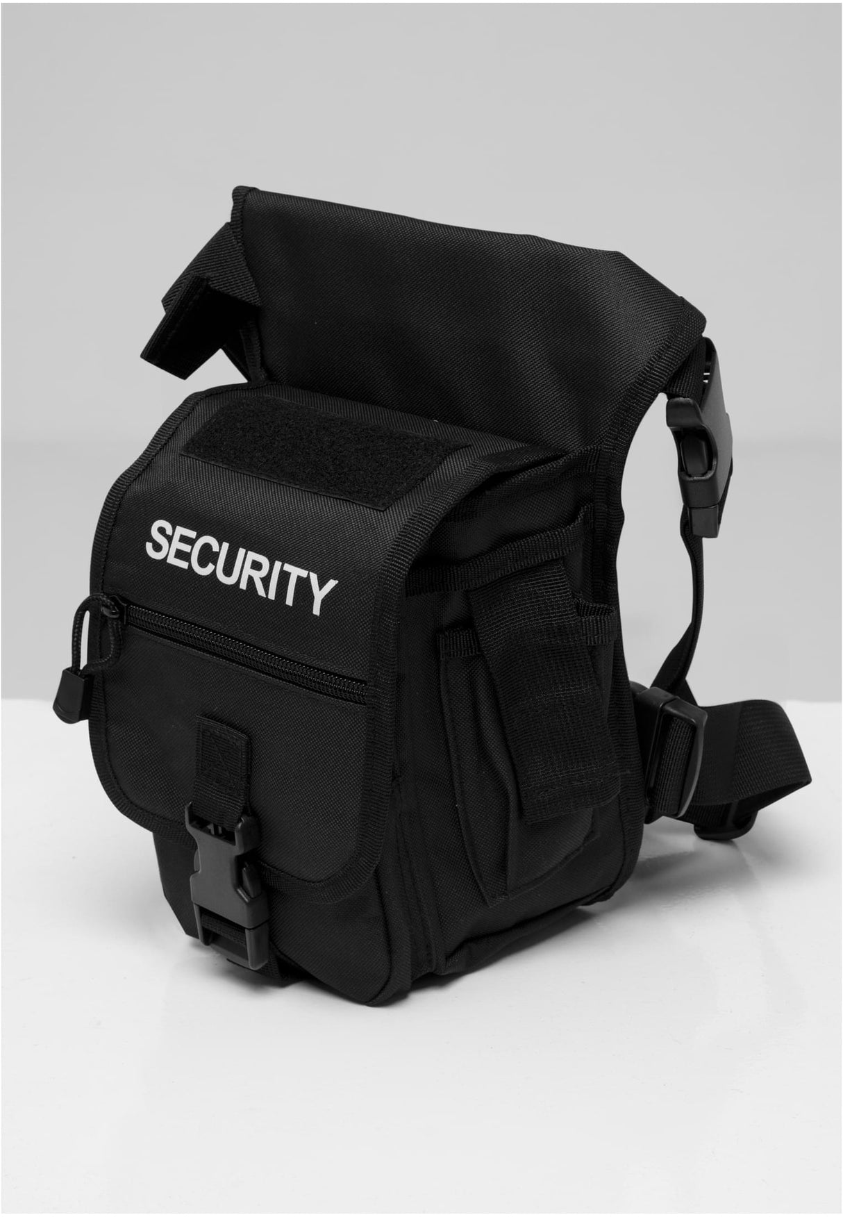 En svart B Security Sidekick Bag med vit 'SECURITY'-text på framsidan, fotograferad mot en ljus bakgrund.