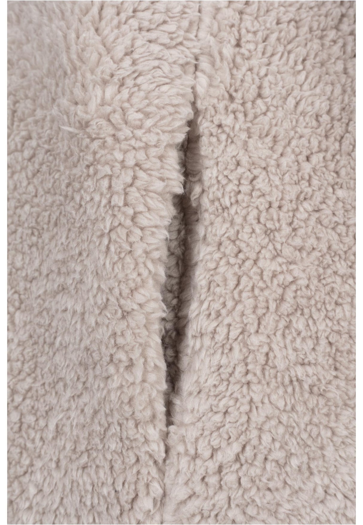 Närbild på det beigea, fluffiga sherpatyget på en UC Sherpa Jacket.