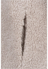 Närbild på det beigea, fluffiga sherpatyget på en UC Sherpa Jacket.